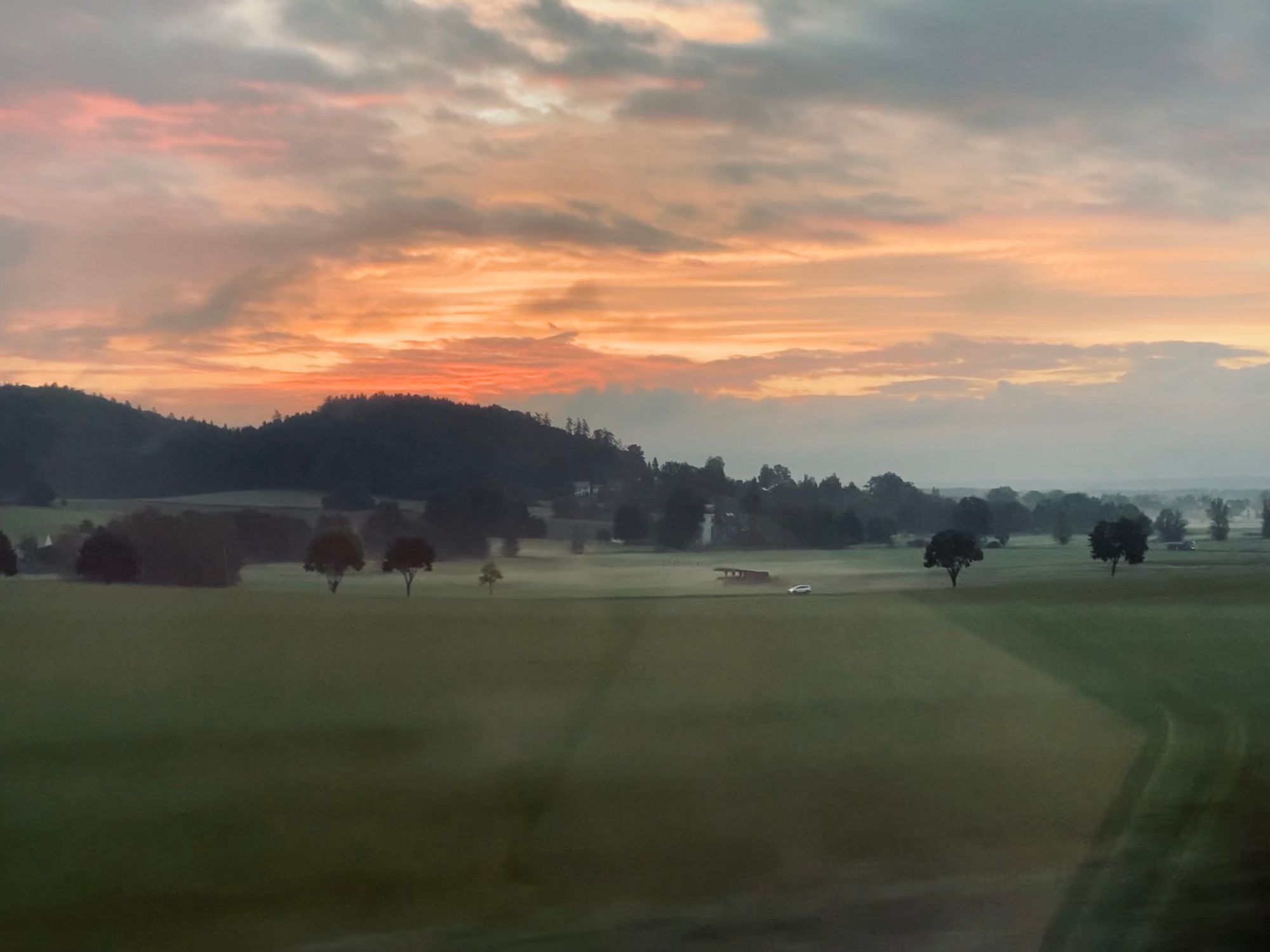 Sunrise over a German village seen from a train window